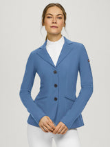 Woman wearing a blue equestrian jacket on a plain background